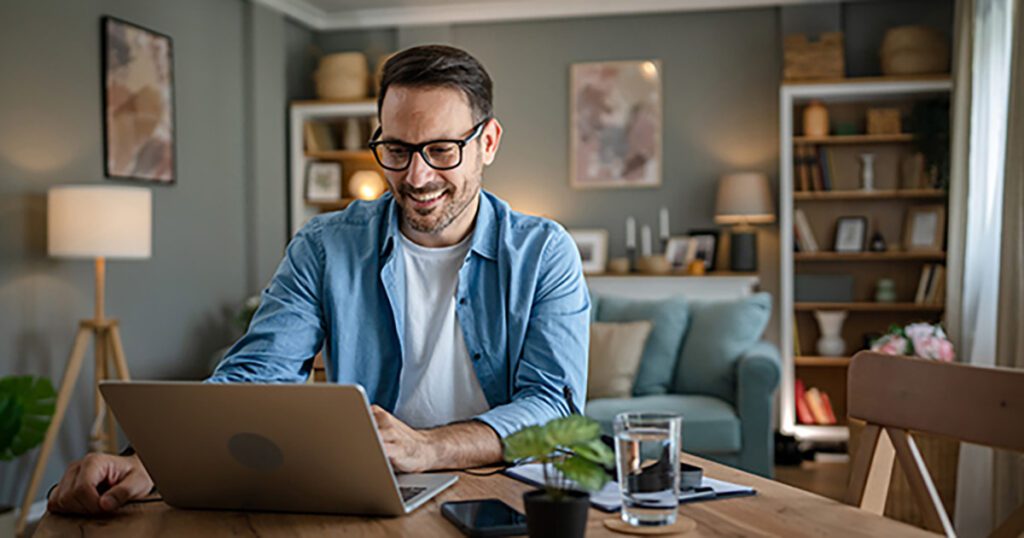 Man at kitchen table on laptop